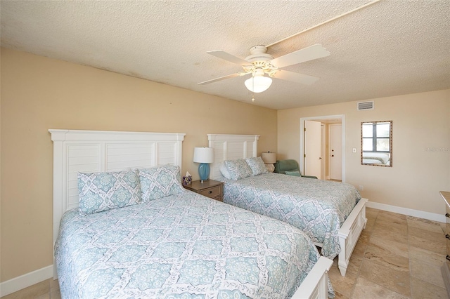 bedroom with ceiling fan and a textured ceiling