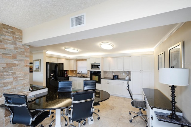 kitchen with backsplash, black appliances, sink, light tile patterned flooring, and white cabinetry