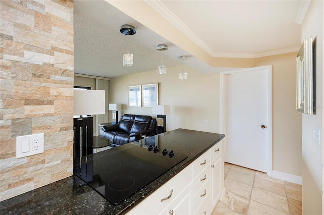 kitchen featuring hanging light fixtures, dark stone counters, black electric stovetop, white cabinets, and ornamental molding