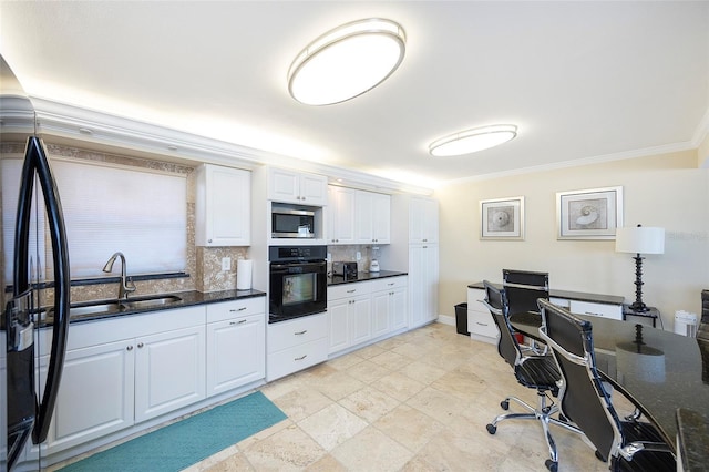 kitchen with appliances with stainless steel finishes, dark stone counters, crown molding, sink, and white cabinets