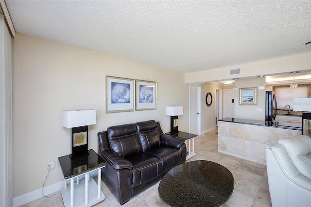 living room with sink and a textured ceiling