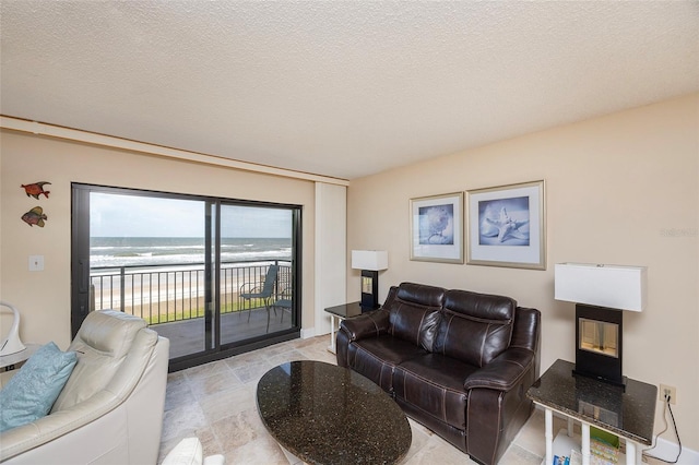 living room featuring a water view and a textured ceiling