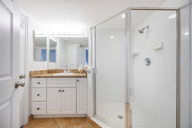 bathroom featuring tile patterned flooring, vanity, and a shower with shower door