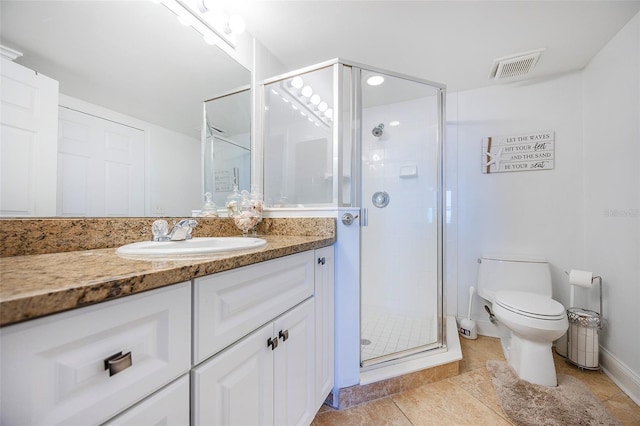 bathroom featuring tile patterned floors, vanity, toilet, and a shower with door