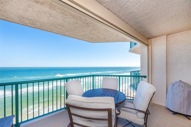 balcony featuring a water view and a view of the beach