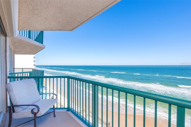 balcony featuring a water view and a beach view