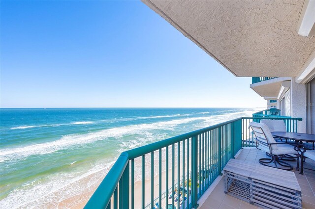 balcony featuring a water view and a view of the beach