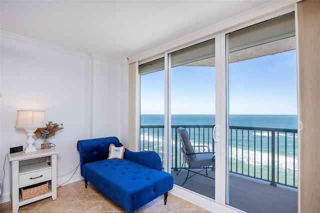 sitting room with a beach view, a water view, light tile patterned floors, and ornamental molding