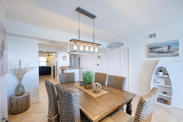 tiled dining space featuring ornamental molding