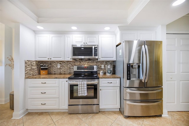 kitchen with white cabinets, backsplash, dark stone countertops, and stainless steel appliances