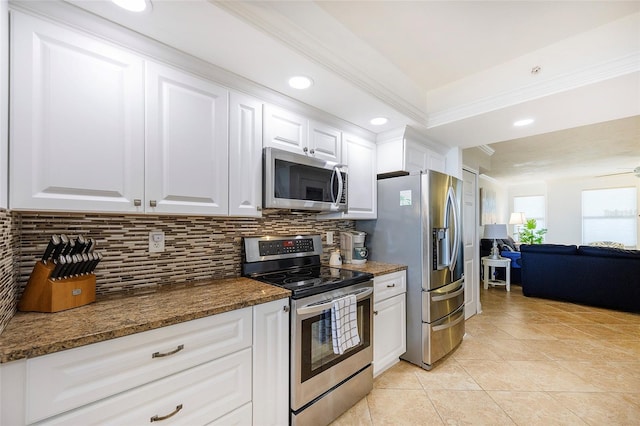 kitchen with white cabinetry, ceiling fan, stainless steel appliances, dark stone countertops, and light tile patterned floors