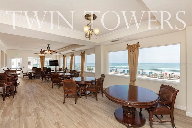 dining room with a tray ceiling, crown molding, ceiling fan with notable chandelier, and hardwood / wood-style flooring