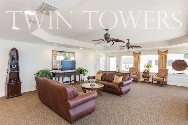 carpeted living room with a raised ceiling, a wealth of natural light, ornamental molding, and ceiling fan