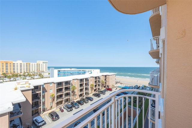 balcony featuring a water view and a beach view