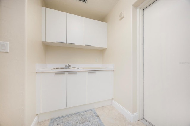 interior space with light tile patterned floors and sink