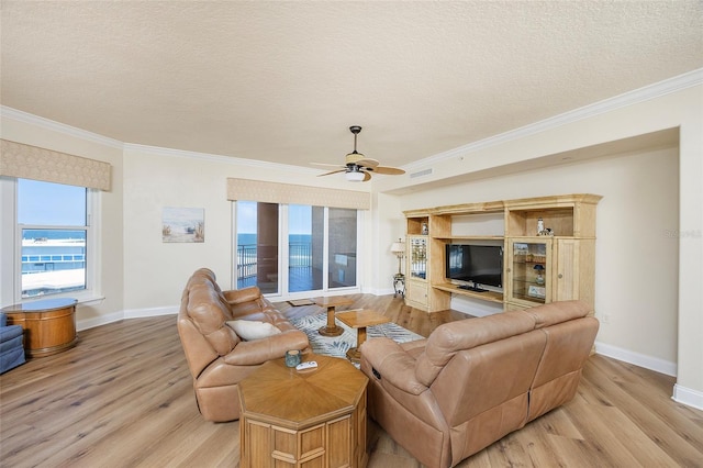 living room featuring ceiling fan, crown molding, a textured ceiling, and light hardwood / wood-style flooring