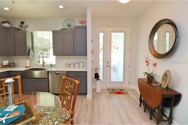 kitchen with sink, stainless steel dishwasher, and light hardwood / wood-style floors