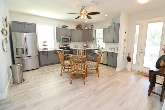 kitchen with stainless steel appliances, ceiling fan, sink, light hardwood / wood-style flooring, and gray cabinets