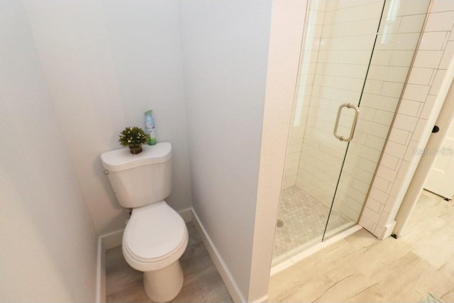 bathroom featuring wood-type flooring, toilet, and an enclosed shower