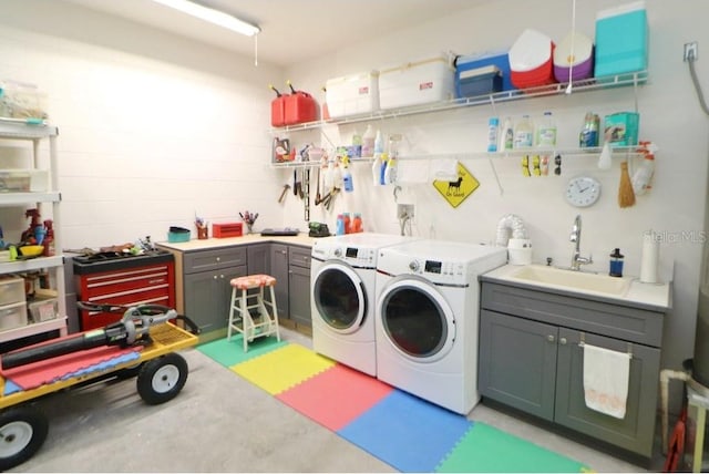 washroom featuring cabinets, independent washer and dryer, and sink