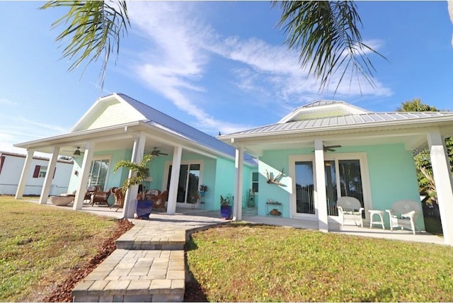 rear view of house with a patio area, ceiling fan, and a yard