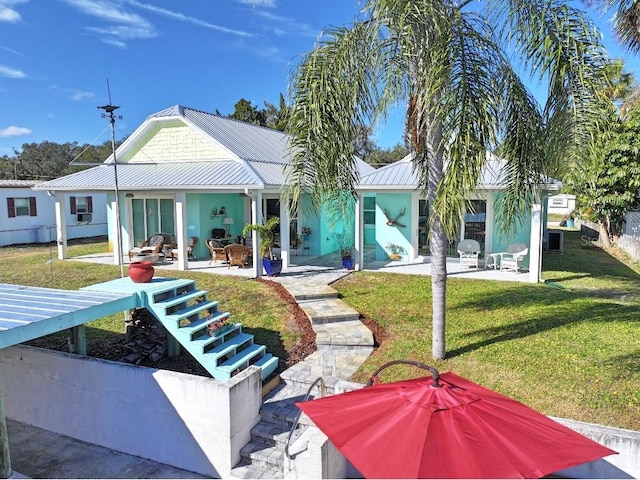 rear view of property with a lawn and a patio area