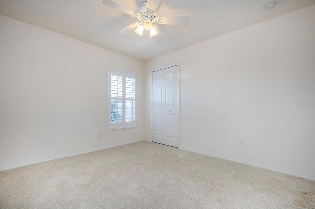 unfurnished room featuring ceiling fan and light colored carpet