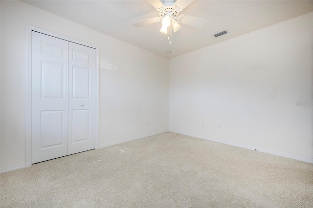 carpeted spare room with ceiling fan