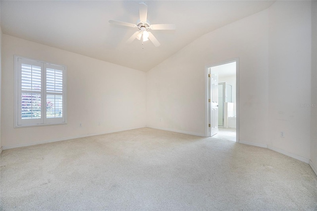 spare room featuring ceiling fan, light colored carpet, and lofted ceiling