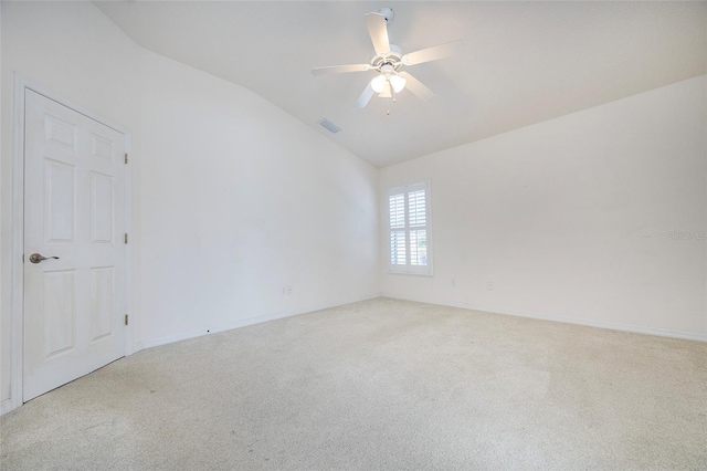 empty room with ceiling fan, light colored carpet, and vaulted ceiling