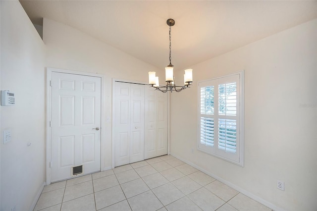 unfurnished dining area featuring light tile patterned floors, a chandelier, and vaulted ceiling