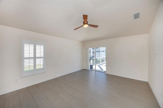 unfurnished room featuring a textured ceiling, a wealth of natural light, and ceiling fan