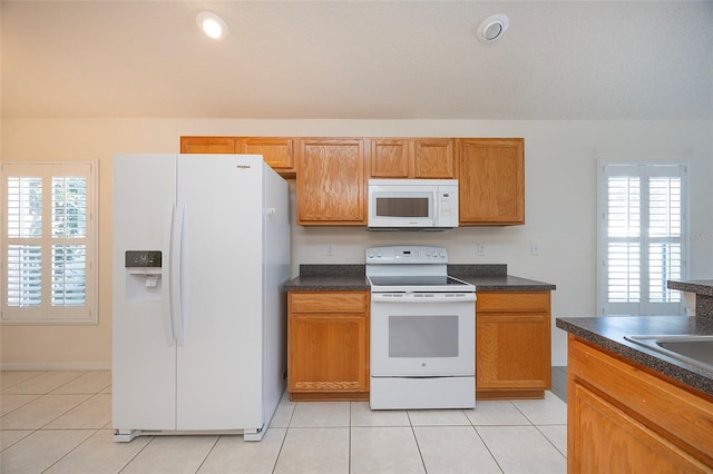 kitchen with light tile patterned flooring and white appliances