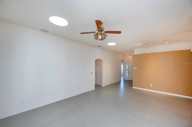 empty room with ceiling fan and a textured ceiling