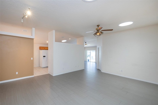 empty room with ceiling fan and a textured ceiling