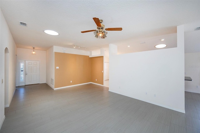 unfurnished room featuring ceiling fan and a textured ceiling