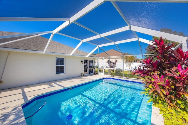 view of swimming pool featuring a patio and glass enclosure