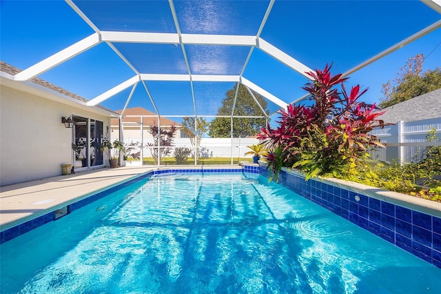 view of swimming pool featuring glass enclosure