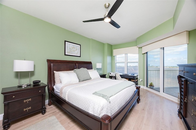 bedroom with access to outside, ceiling fan, a water view, and light hardwood / wood-style floors