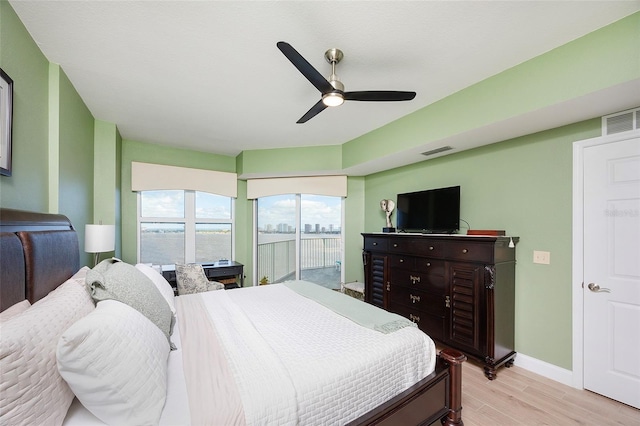 bedroom featuring access to exterior, light hardwood / wood-style floors, and ceiling fan