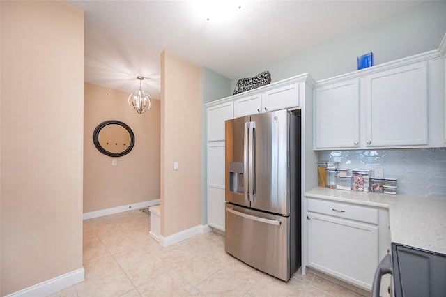 kitchen with backsplash, white cabinets, stainless steel refrigerator with ice dispenser, and an inviting chandelier