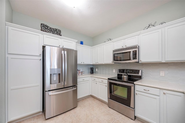 kitchen featuring decorative backsplash, light stone counters, white cabinetry, and stainless steel appliances