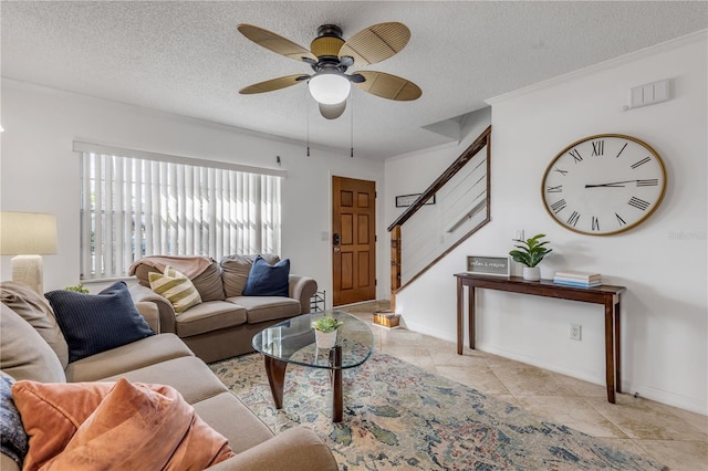 tiled living room with a textured ceiling, ceiling fan, and ornamental molding