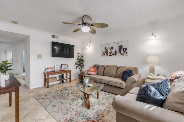 living room with ceiling fan, a textured ceiling, and ornamental molding