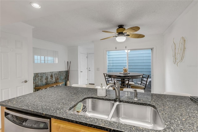 kitchen featuring ceiling fan, dishwasher, a textured ceiling, and sink