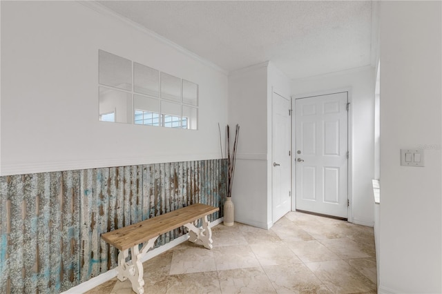 entrance foyer featuring a textured ceiling and ornamental molding