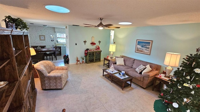 tiled living room with ceiling fan and a textured ceiling