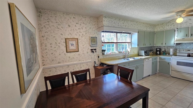 kitchen with white appliances, sink, ceiling fan, light tile patterned floors, and a textured ceiling