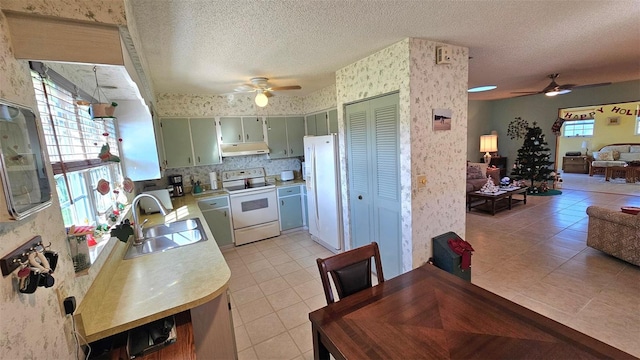 kitchen with ceiling fan, sink, white electric range, a textured ceiling, and light tile patterned flooring