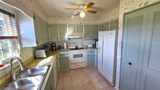 kitchen featuring a textured ceiling, white appliances, ceiling fan, sink, and light tile patterned floors